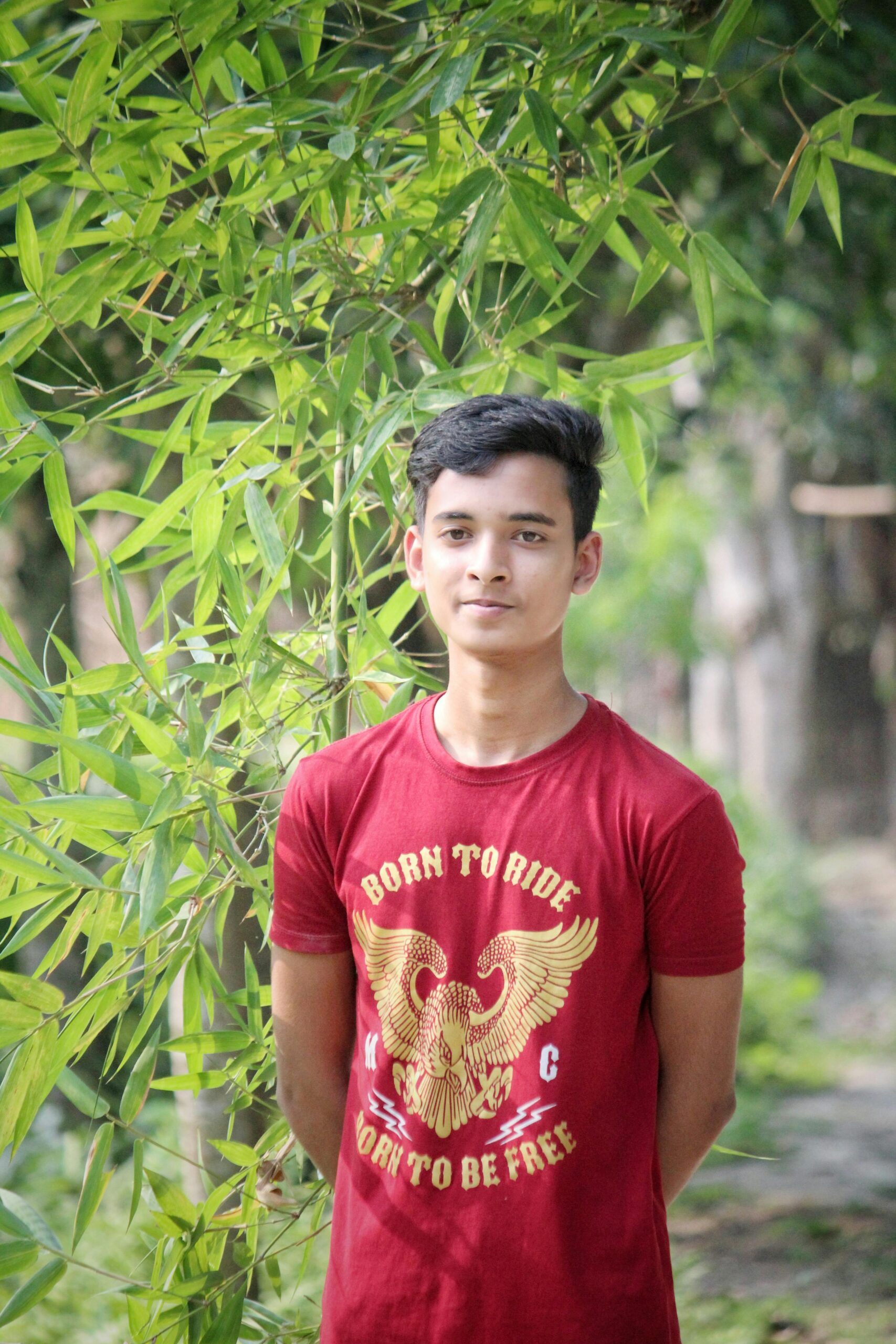 Reviews / Testimonials Page Teen posing outdoors among greenery in a t-shirt with an eagle design.